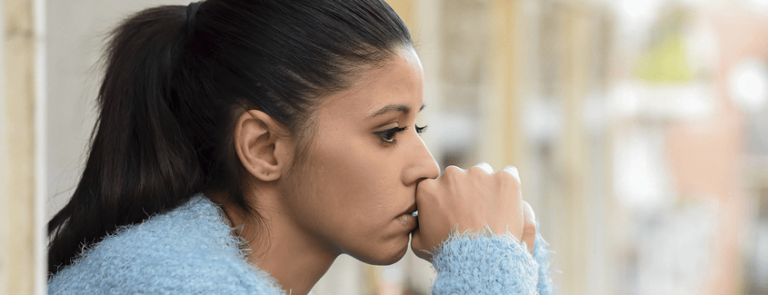 A woman sitting alone thinking about her alcohol addiction and depression symptoms.