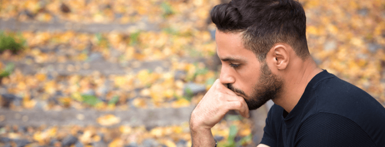 A man sitting alone wondering if he’s addicted to painkillers.
