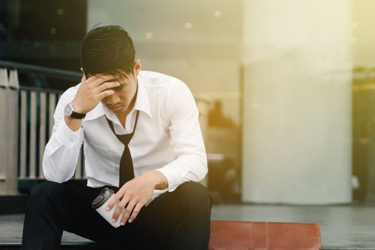 A distraught professional man wondering how to overcome cocaine addiction.