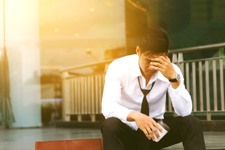A business man sits with his head in his hand, wondering why heroin is so addictive.