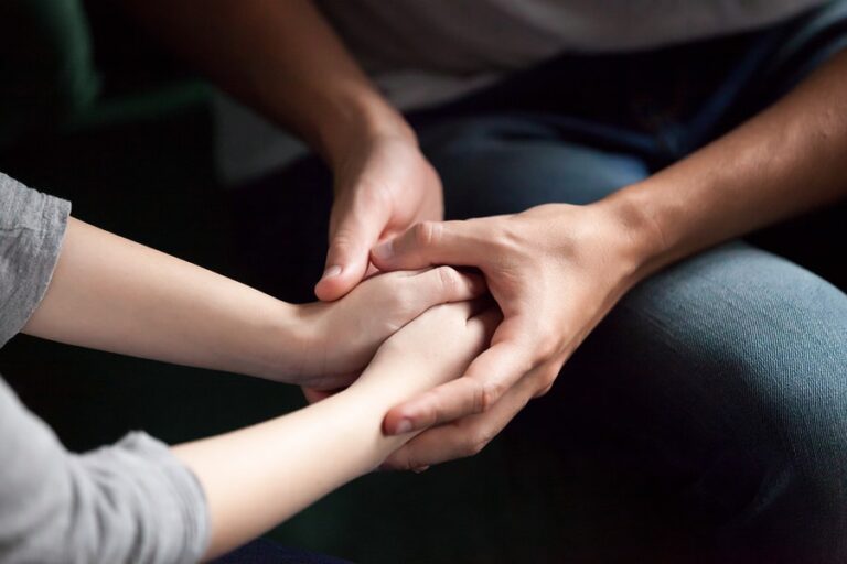 Loved ones holding hands and discussing dialectical behavior therapy for anxiety.