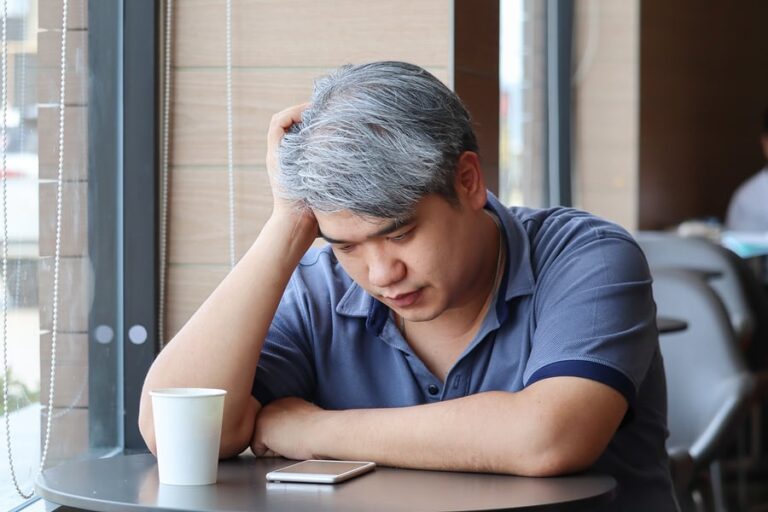 A man sits and stares at his phone