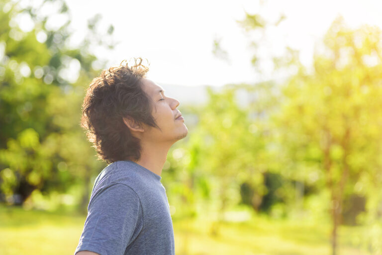 A man stands outside and breathes deep