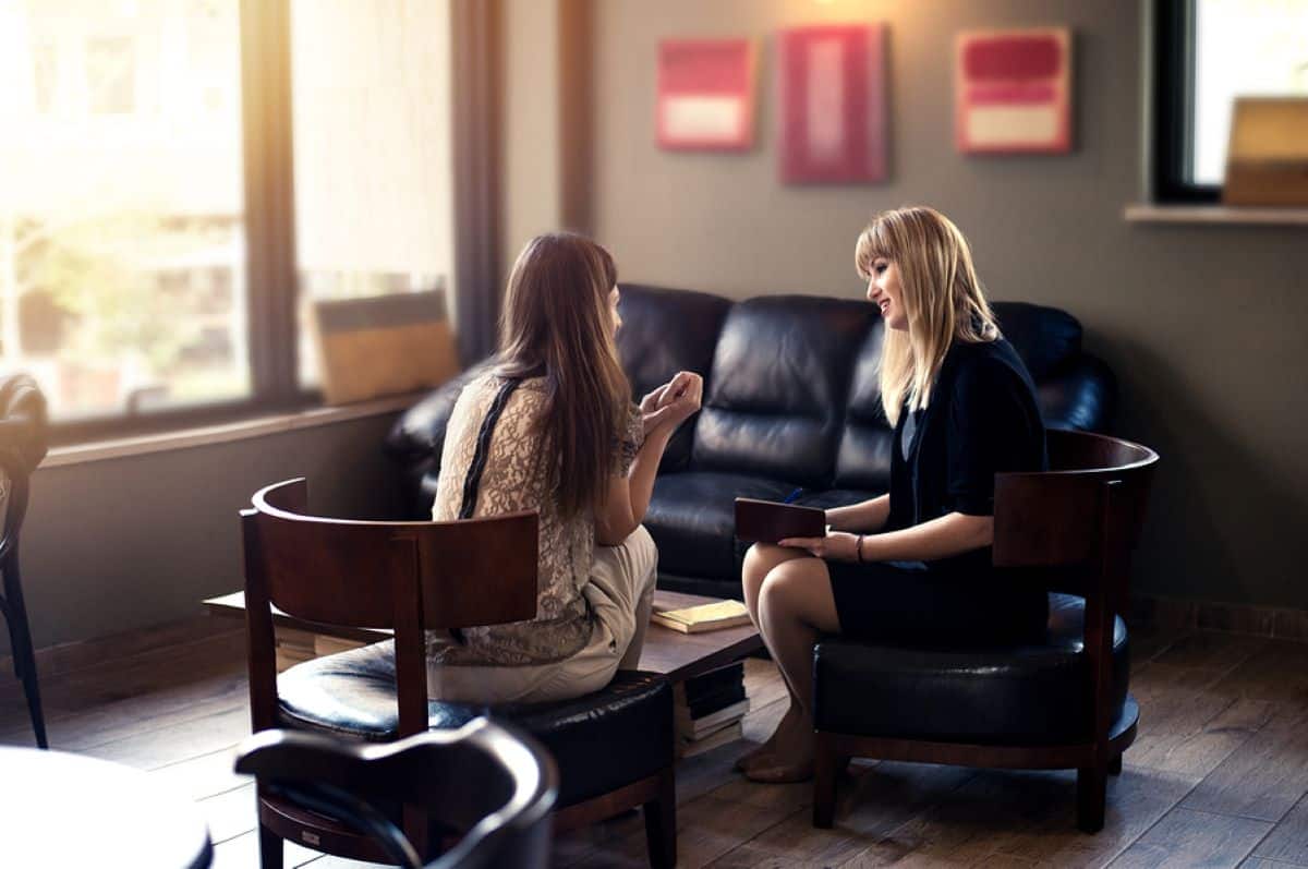 A recovering addict and a female therapist talk during a dialectical behavior therapy session.