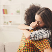 Two women embrace and discuss how to manage a loved one's relapse.