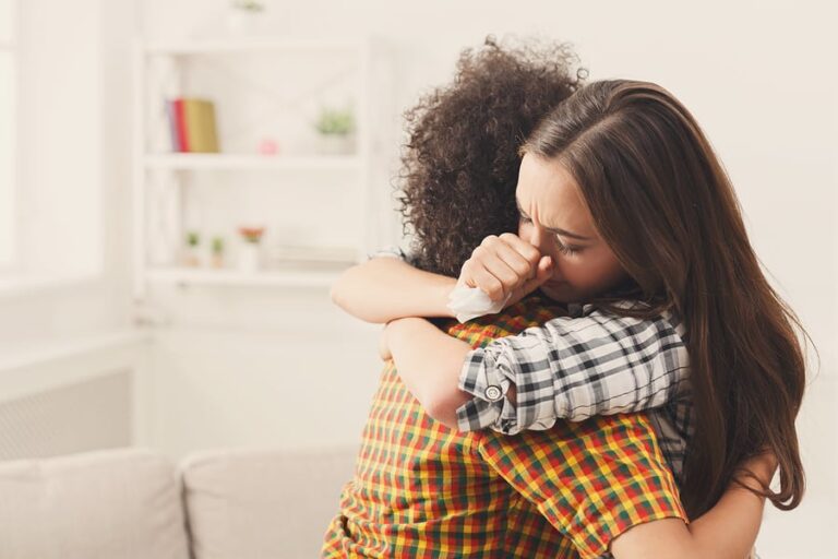 Two women embrace and discuss how to manage a loved one's relapse.