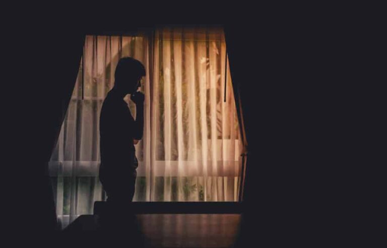 A silhouette of a man thinking “When should I go to rehab?”