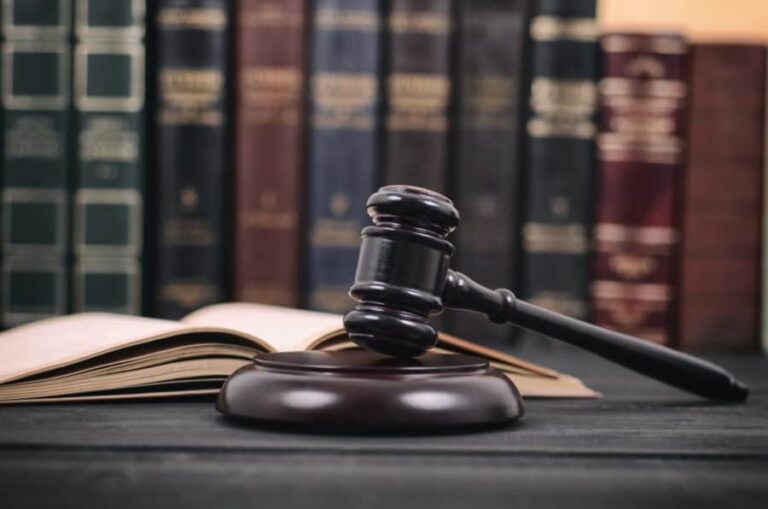 A judge gavel and law book detailing drug possession laws in California.