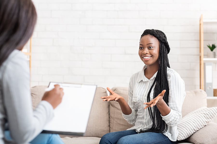 A happy female patient talks with a therapist during outpatient drug treatment