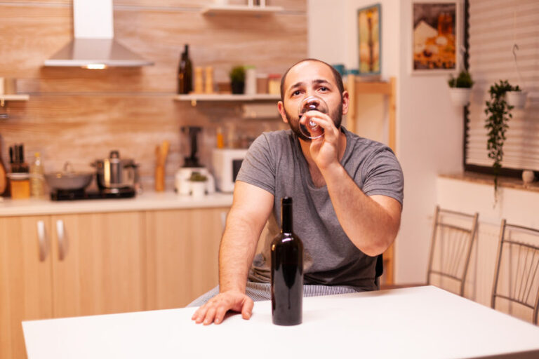 A man drinks a glass of wine in quarantine.