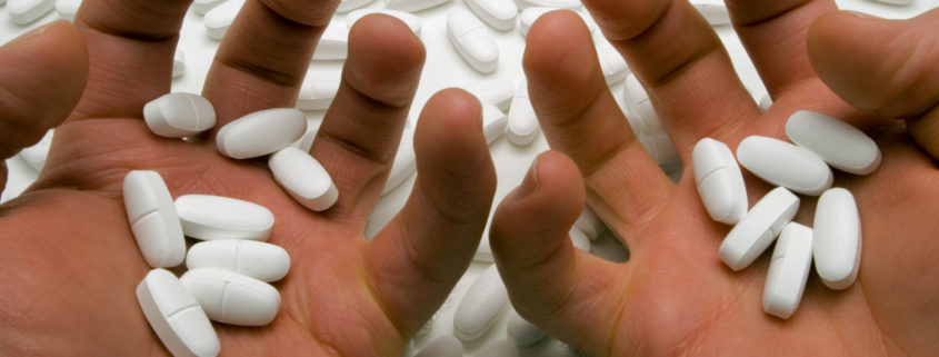 Hands of a person addicted to prescription drugs.