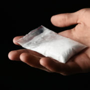 A hand holding a bag of cocaine.
