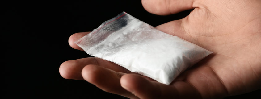 A hand holding a bag of cocaine.