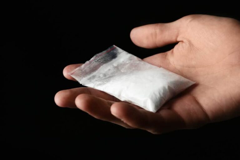 A hand holding a bag of cocaine.