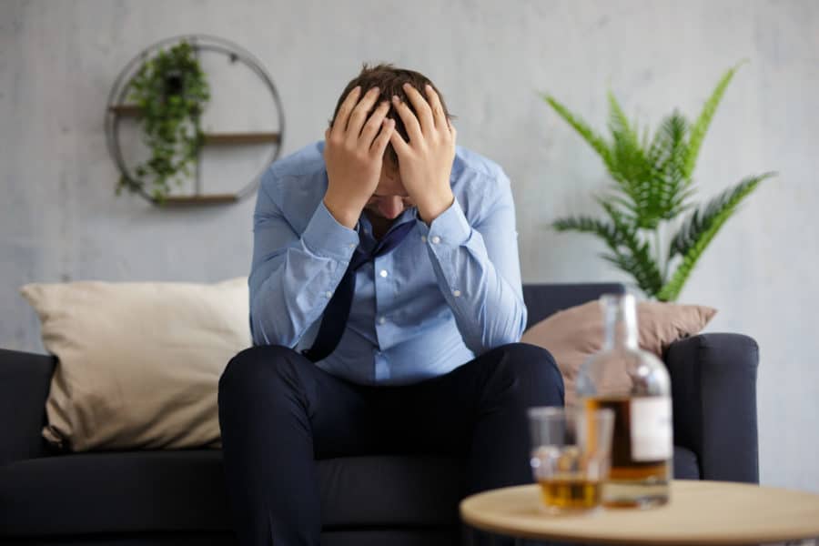 A depressed businessman thinking about alcohol effects on the liver.