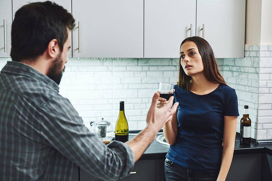 A man and woman get into an argument while she holds a glass of wine