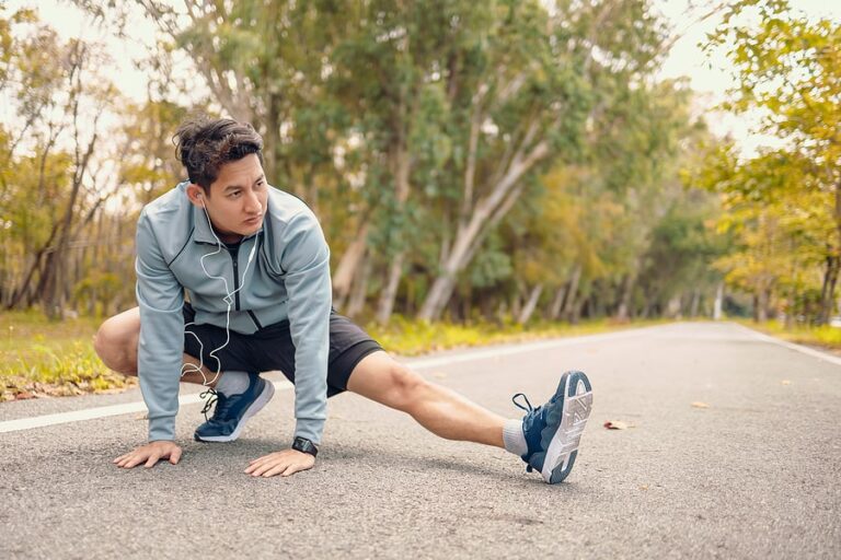 A man stretches in the park before running as part of his addiction recovery routine.