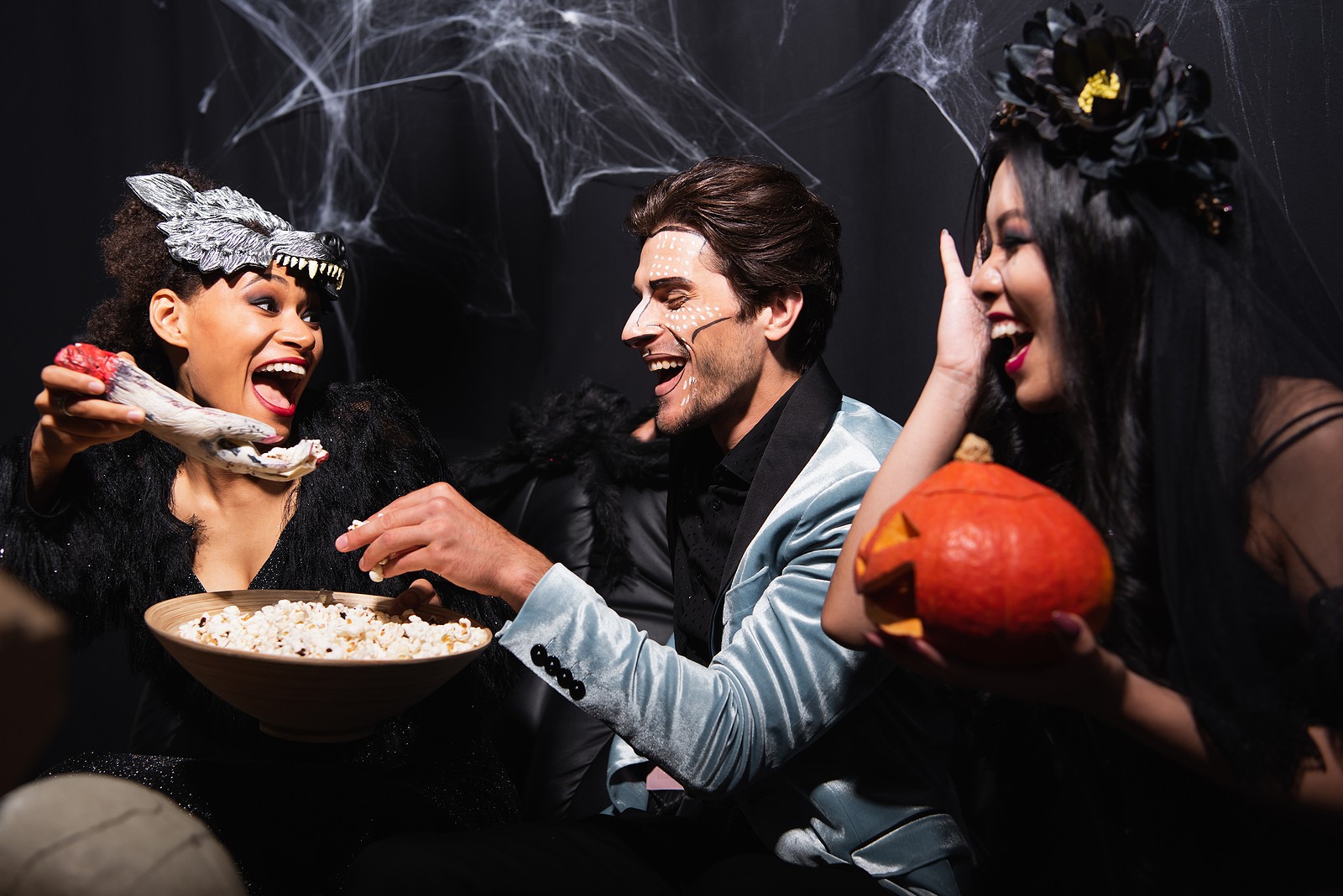 Friends eating popcorn and staying sober on Halloween