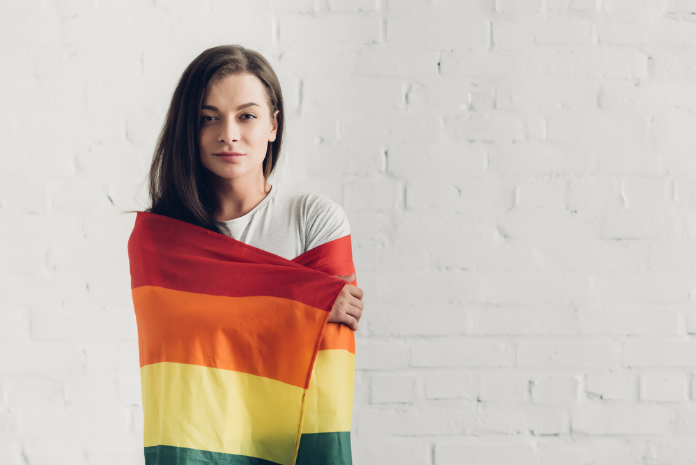 A LGBTQ member hugging a pride flag