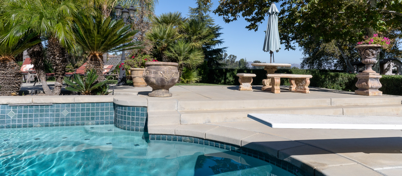 A close up on a diving board in a backyard pool