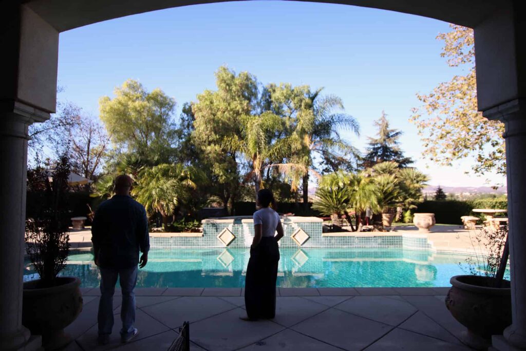 Two people in front of the backyard pool