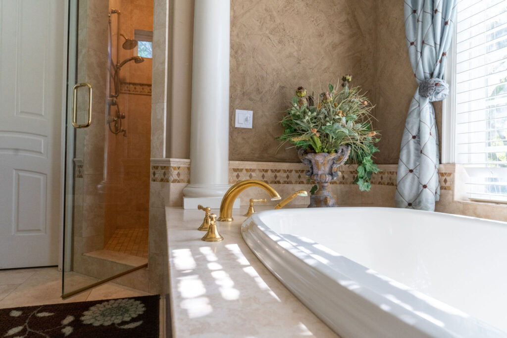 A large soaking tub with gold fixtures