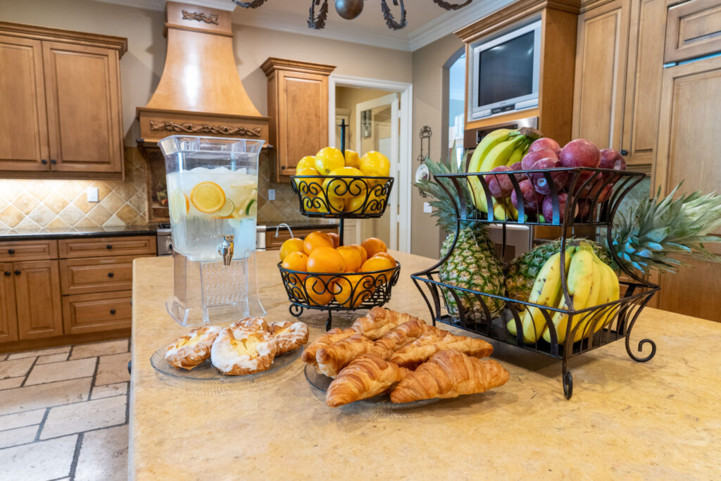 Breakfast and fresh fruit items arranged on a large kitchen island