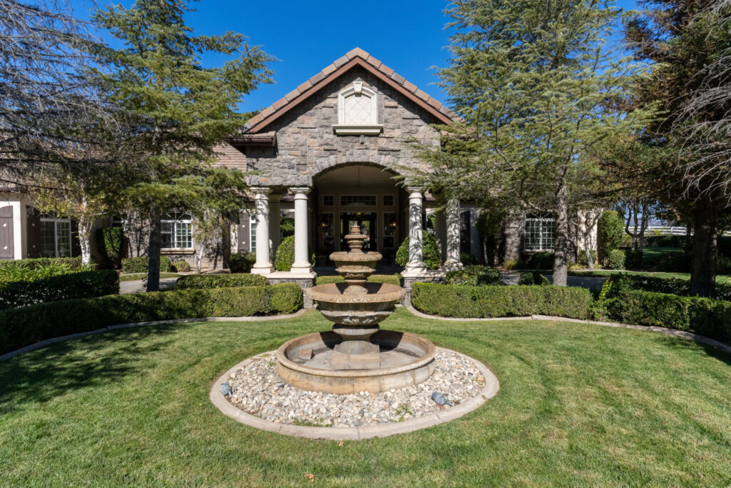 A small stone fountain in front of a house
