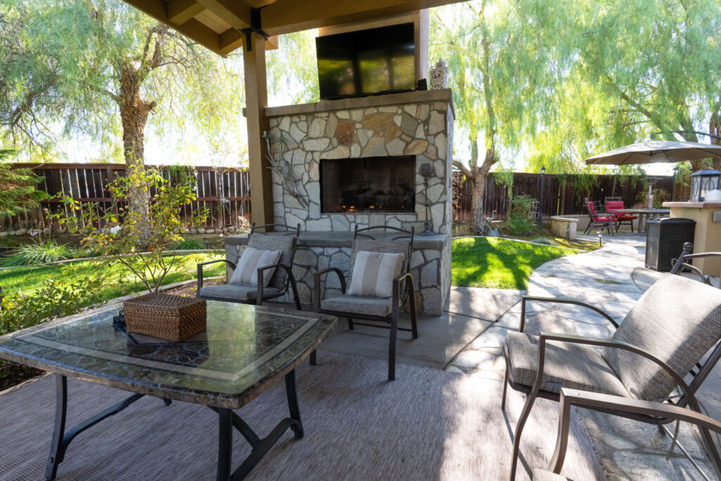 A pergola with a built in fireplace and seating